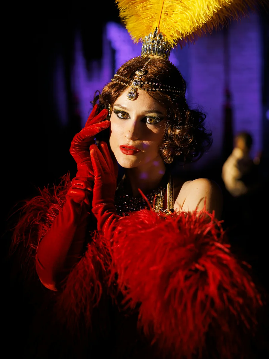A performer in a feathered headpiece and jewelled costume