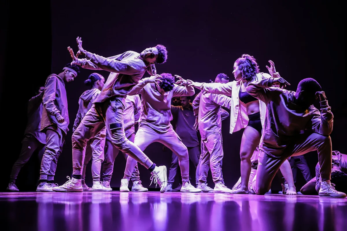 A group of dancers in matching costume mid-performance on stage